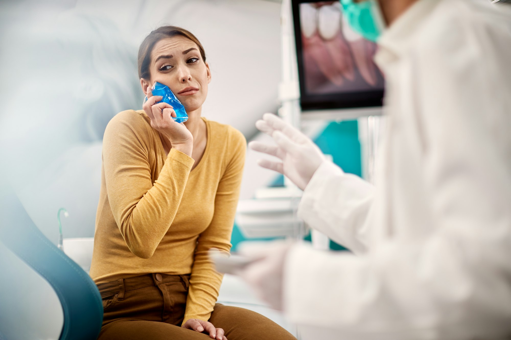 Young woman with toothache having appointment at dentist's office.